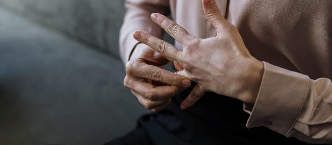 avvocato divorzista: foto delle mani di una persona che si sta togliendo la fede nuziale
